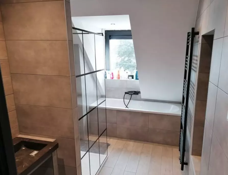 Badkamer in Doetinchem met ligbad en luxe wastafel en ruitenglaswand