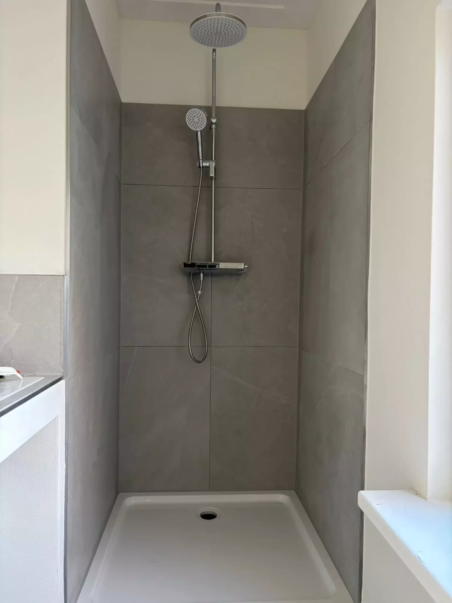 Badkamer renovatie in Almelo met stortbak, stortdouche en lichte kleuren