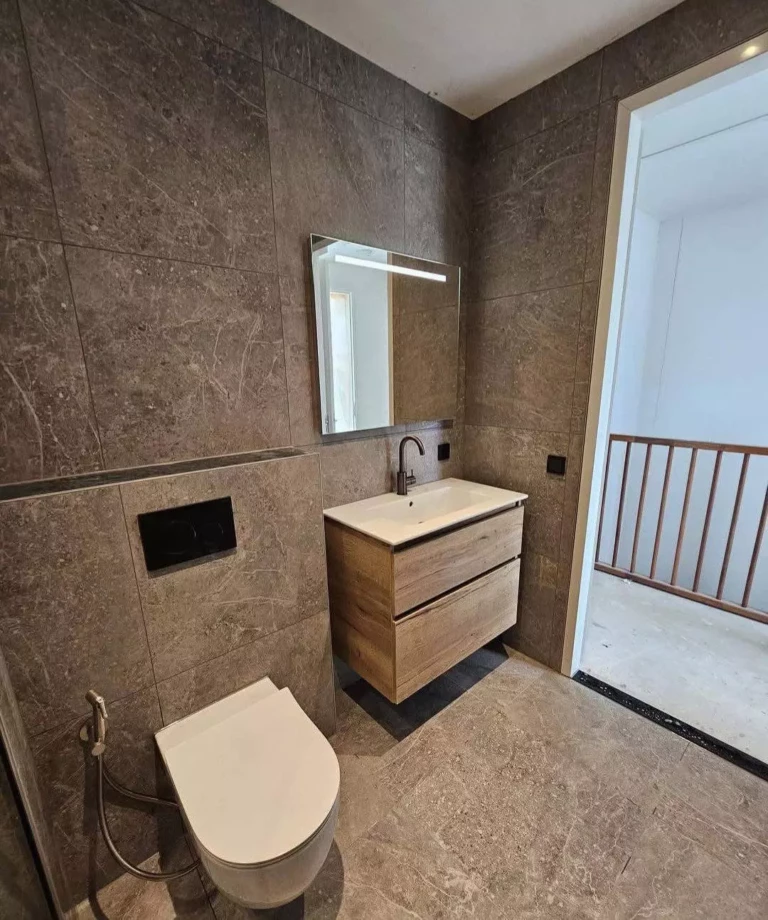 Luxe badkamer renovatie in Deventer met grijze marmerlook tegels en gunmetal kranen2