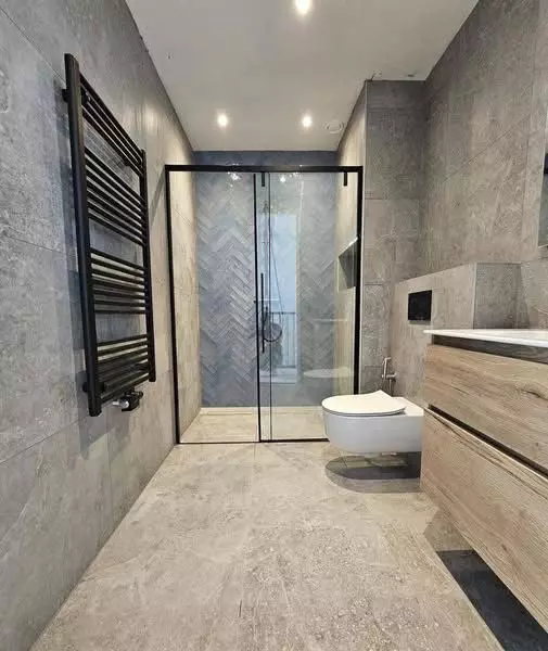 Luxe badkamer renovatie in Deventer met grijze marmerlook tegels en gunmetal kranen3