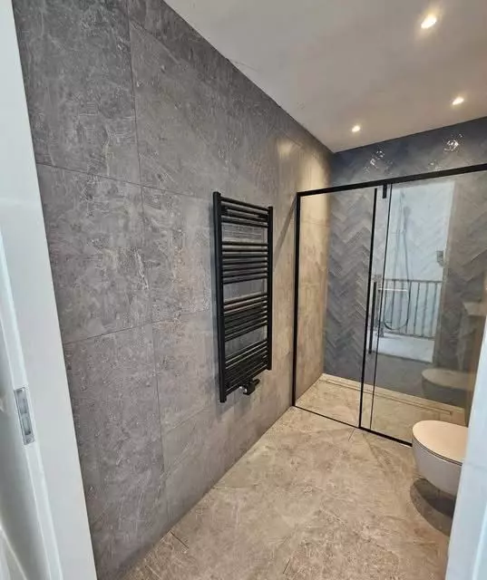 Luxe badkamer renovatie in Deventer met grijze marmerlook tegels en gunmetal kranen4