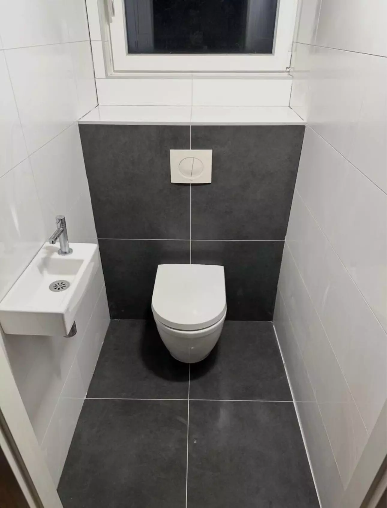 Moderne toiletrenovatie in Almelo met donkere grijze vloer en witte wandtegels