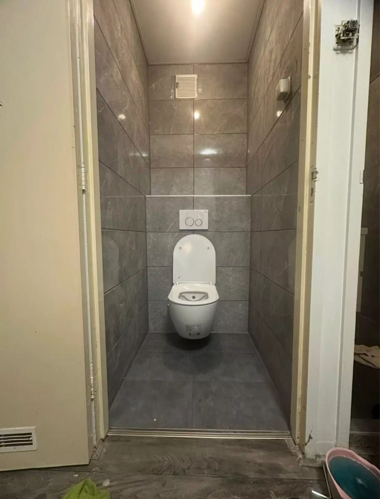 Toilet renovatie in Apeldoorn met grijze glans tegels en modern wit toilet